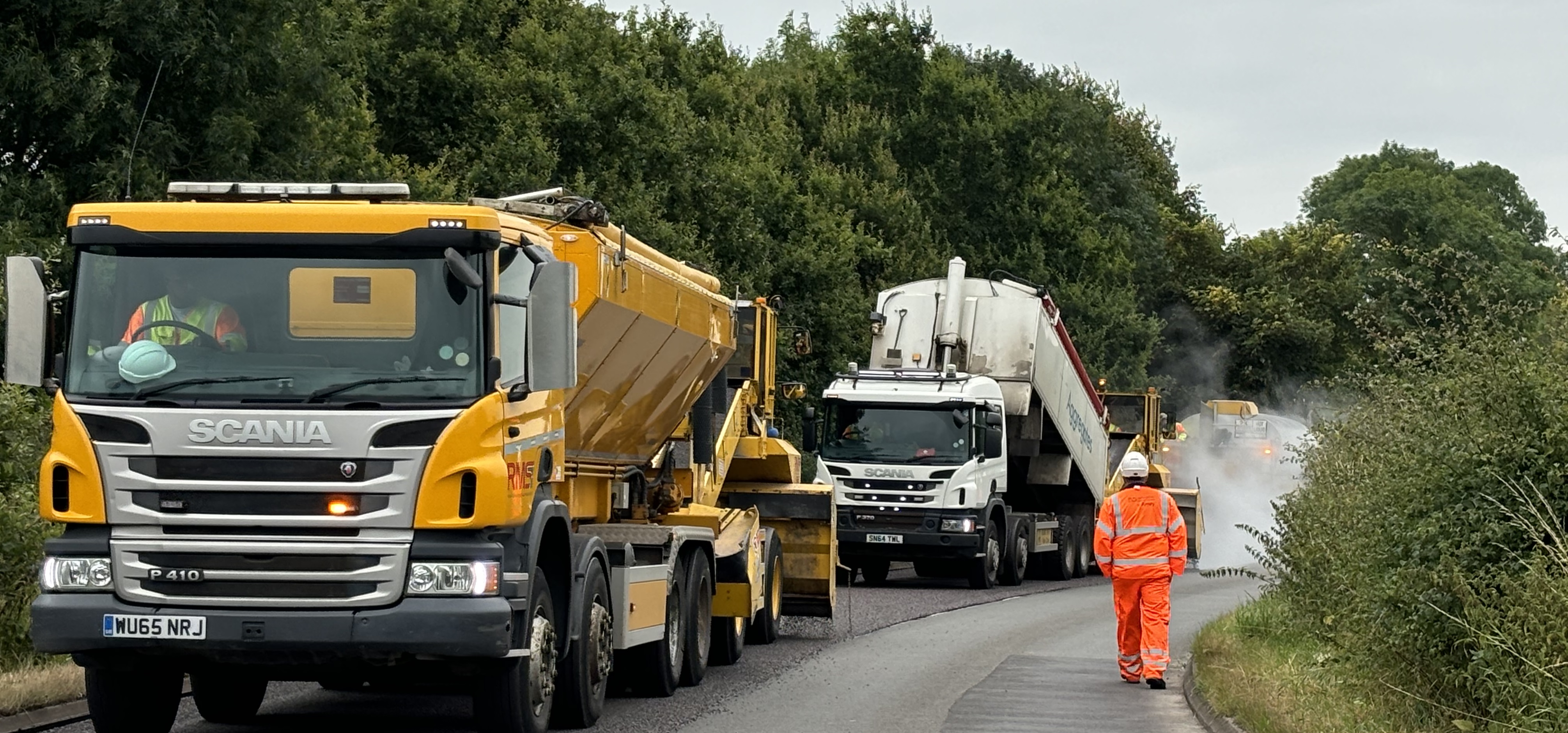 Crew surface dressing a road